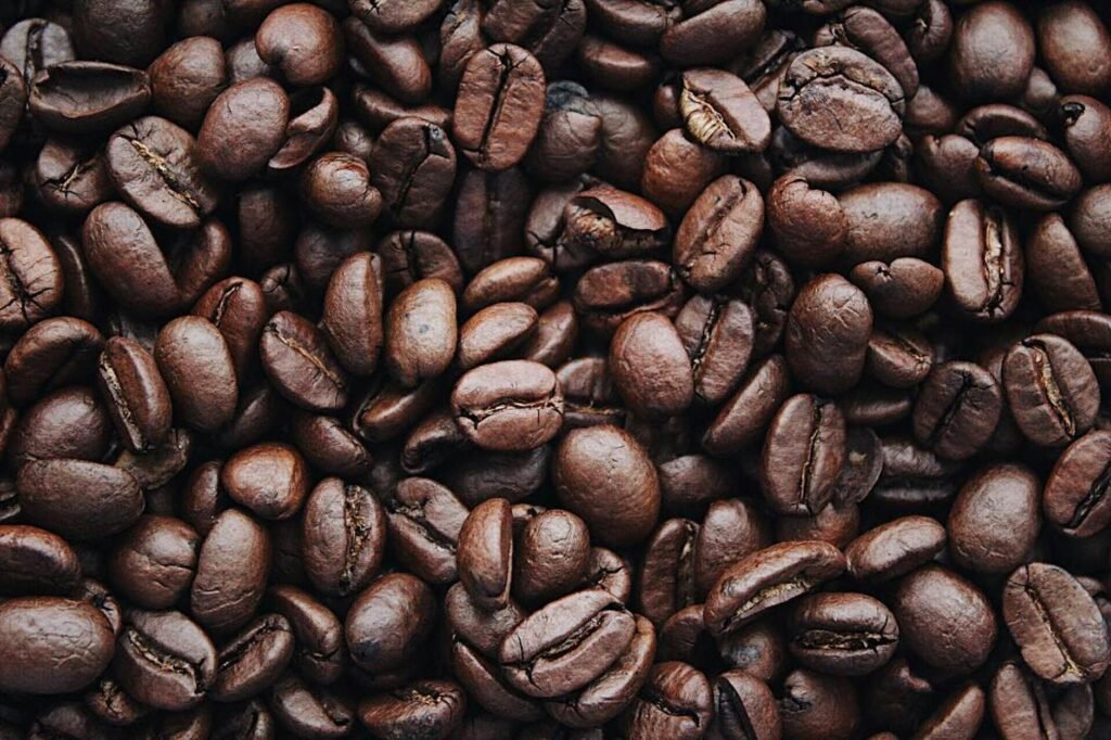 Uma visão detalhada de grãos de café arábica torrados aromáticos, destacando a textura e a cor marrom.