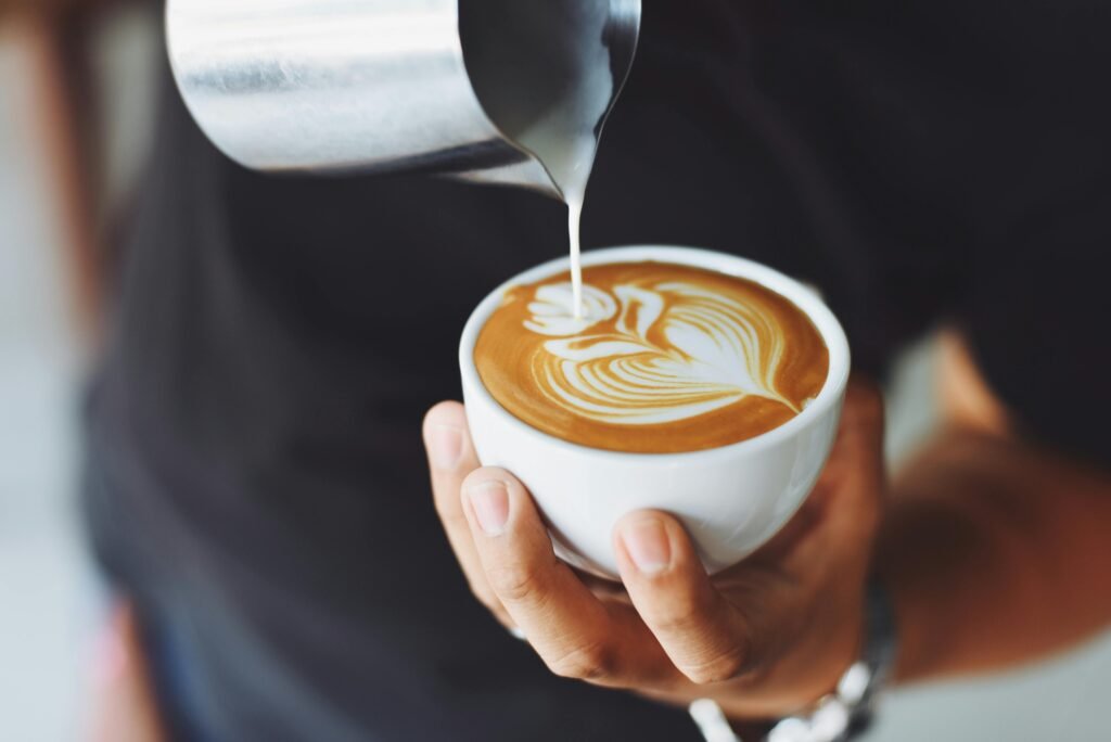 Close de um barista fazendo um LatteArt.